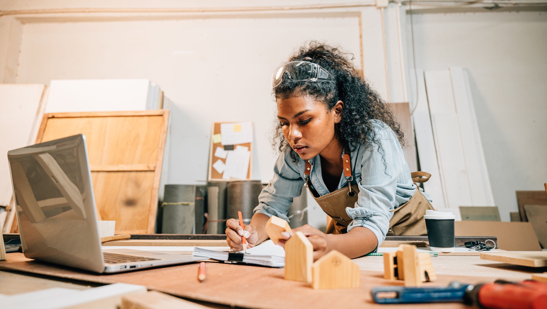Carpenter america black woman curly hair sketch work and making notes in work paper