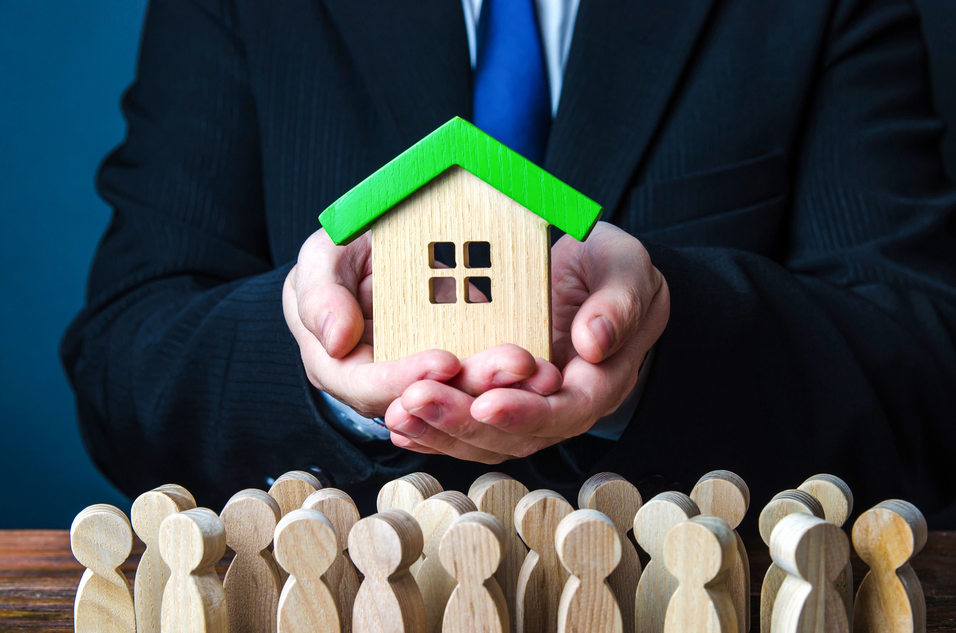 A man presents a house to people. Offer an affordable mortgage loan for home purchase. State guaranteed housing. Providing social real estate for people in need. Rent of apartments and houses.